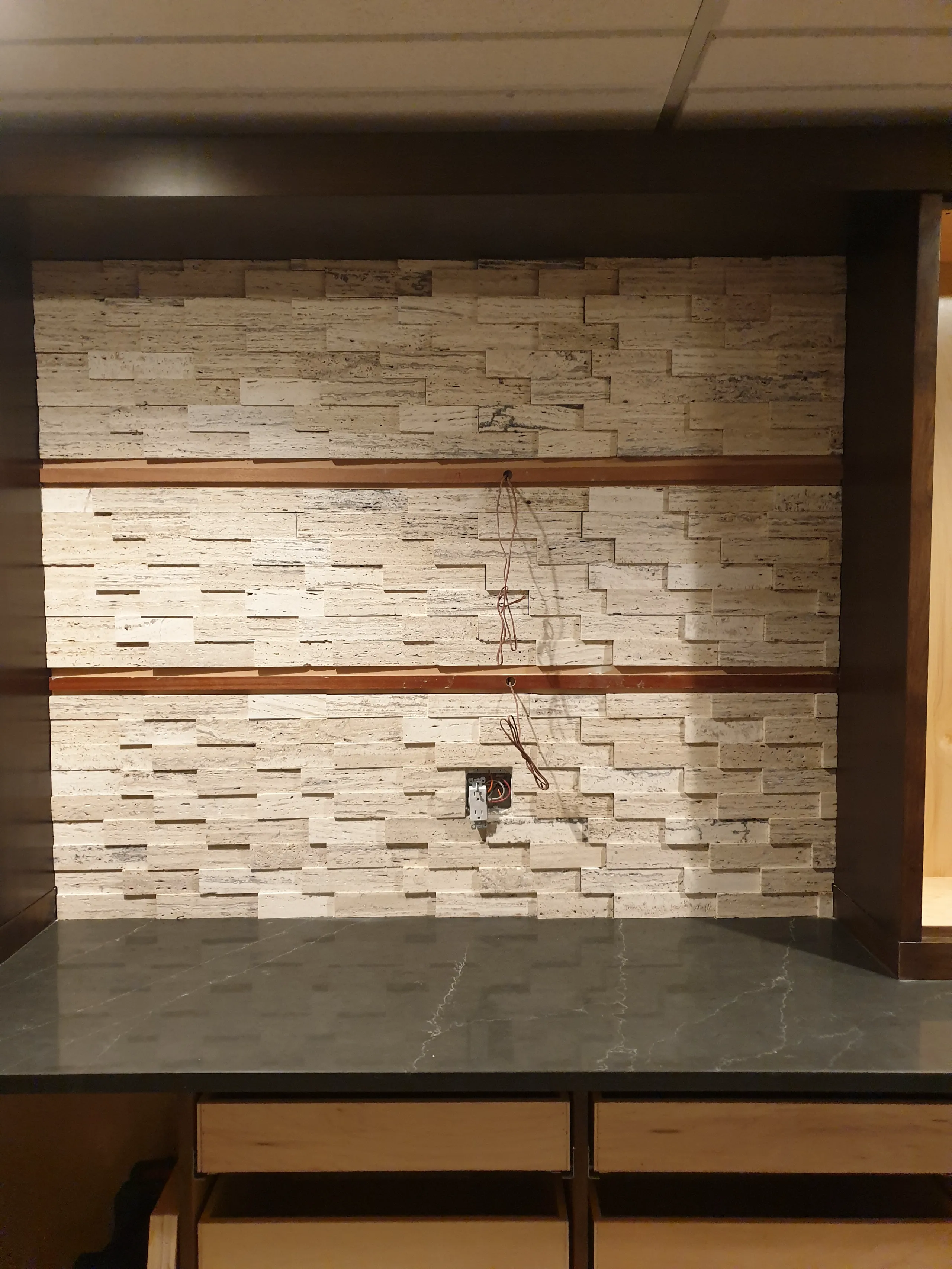 Detailed installation of textured wall tiles with a countertop ready for cabinet installation