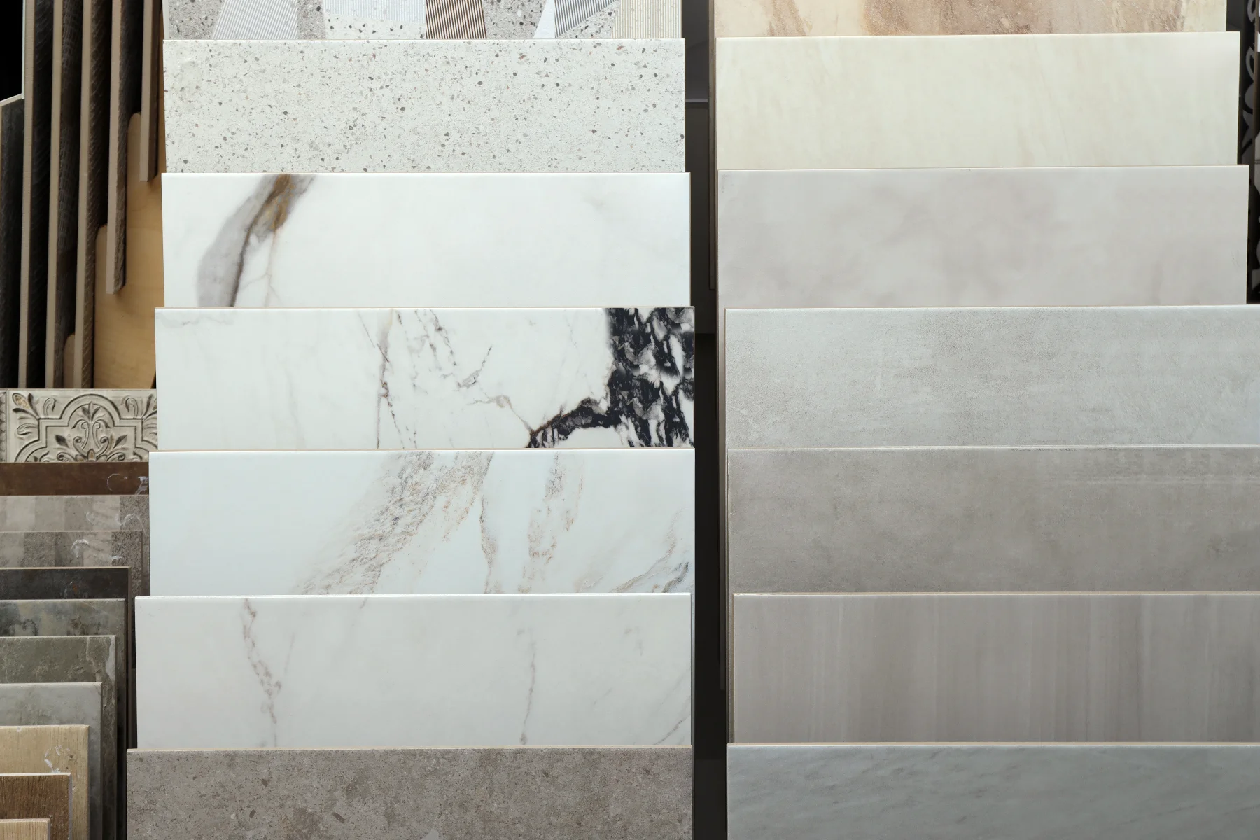Display of various tile samples including marble, granite, and porcelain tiles for renovation projects