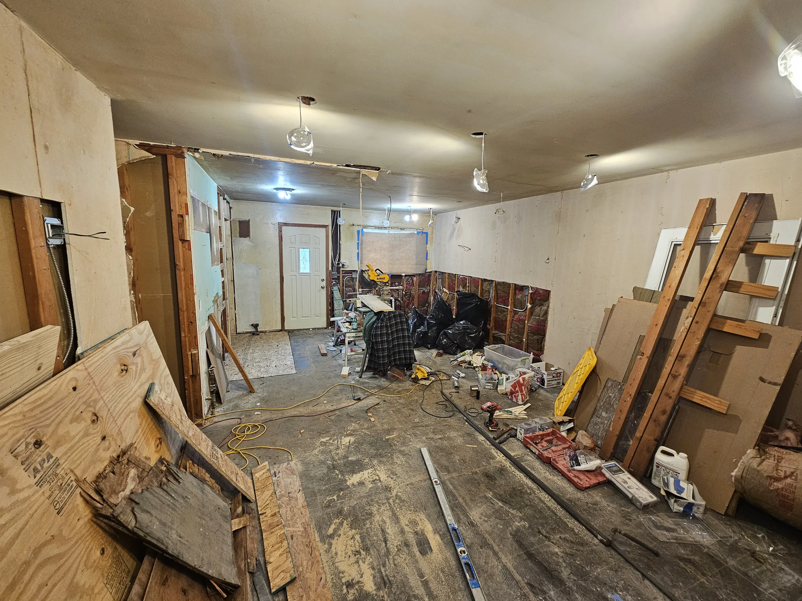 A partially renovated room with exposed walls and construction materials scattered around