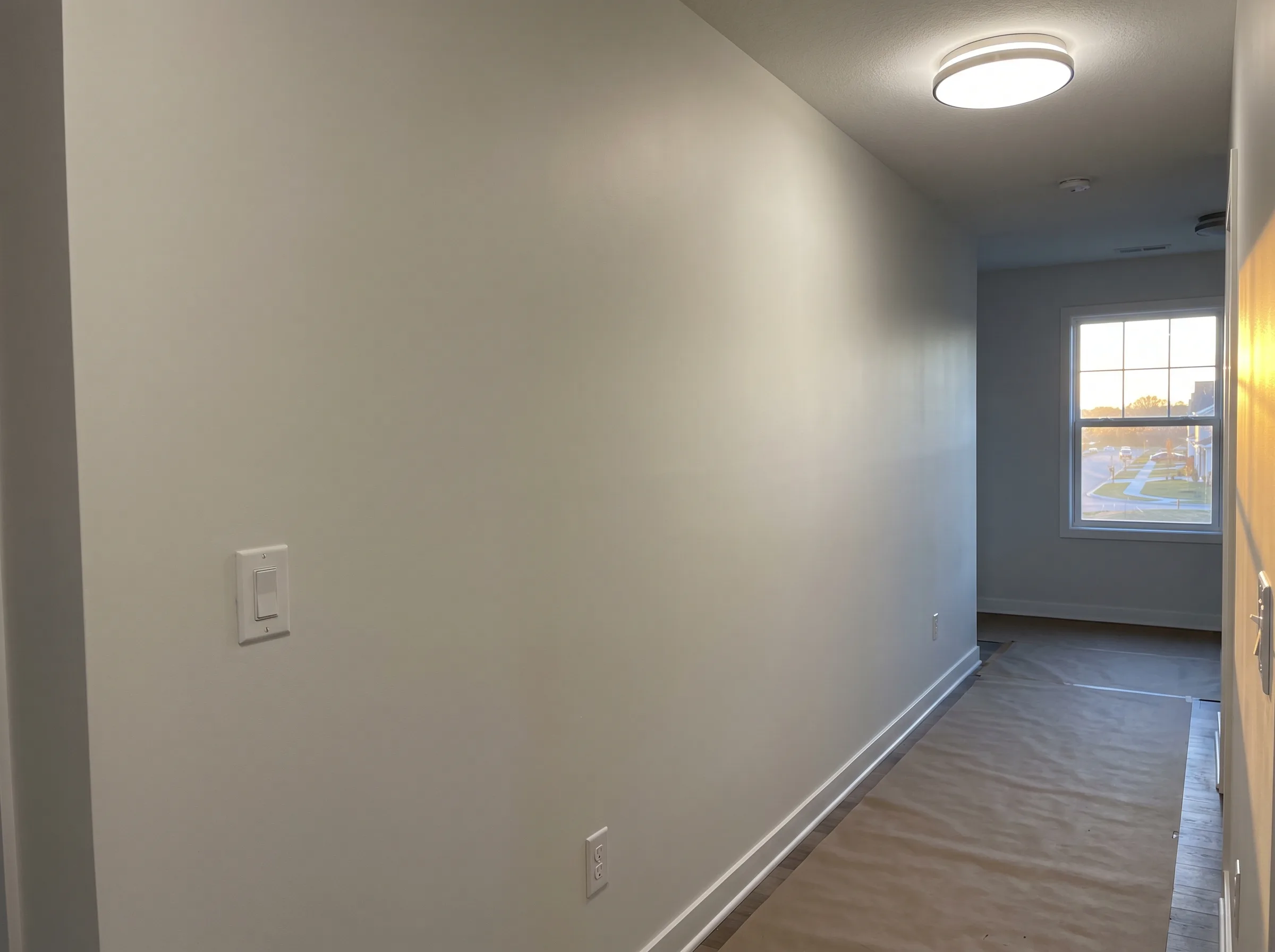 Bright and clean interior hallway with new drywall and lighting