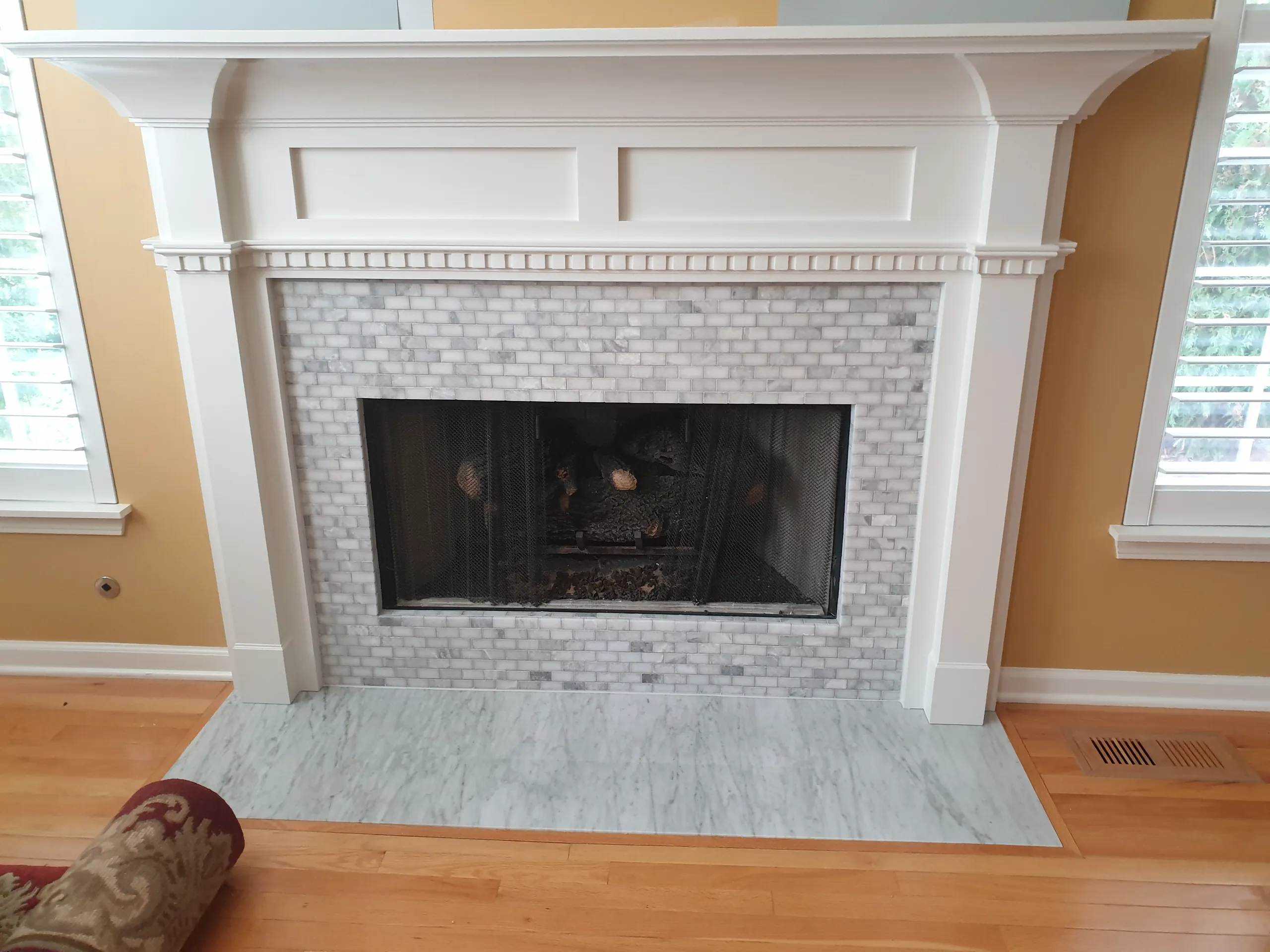 Elegant fireplace with marble surround and glass screen, enhancing interior design
