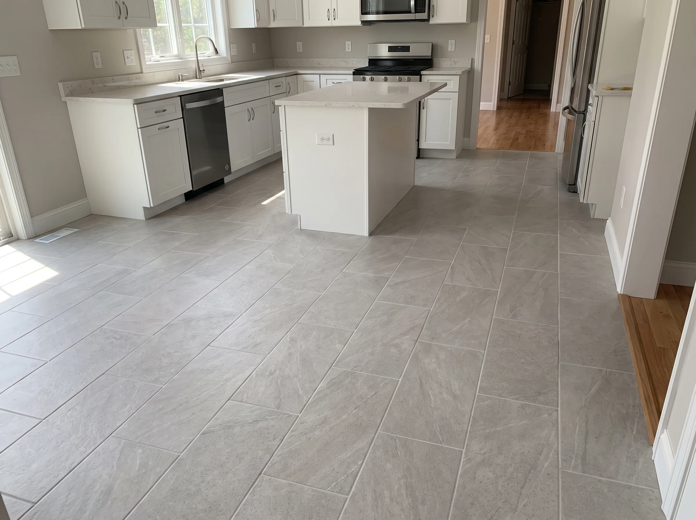 Modern kitchen with gray tile flooring and an island, showcasing a sleek renovation