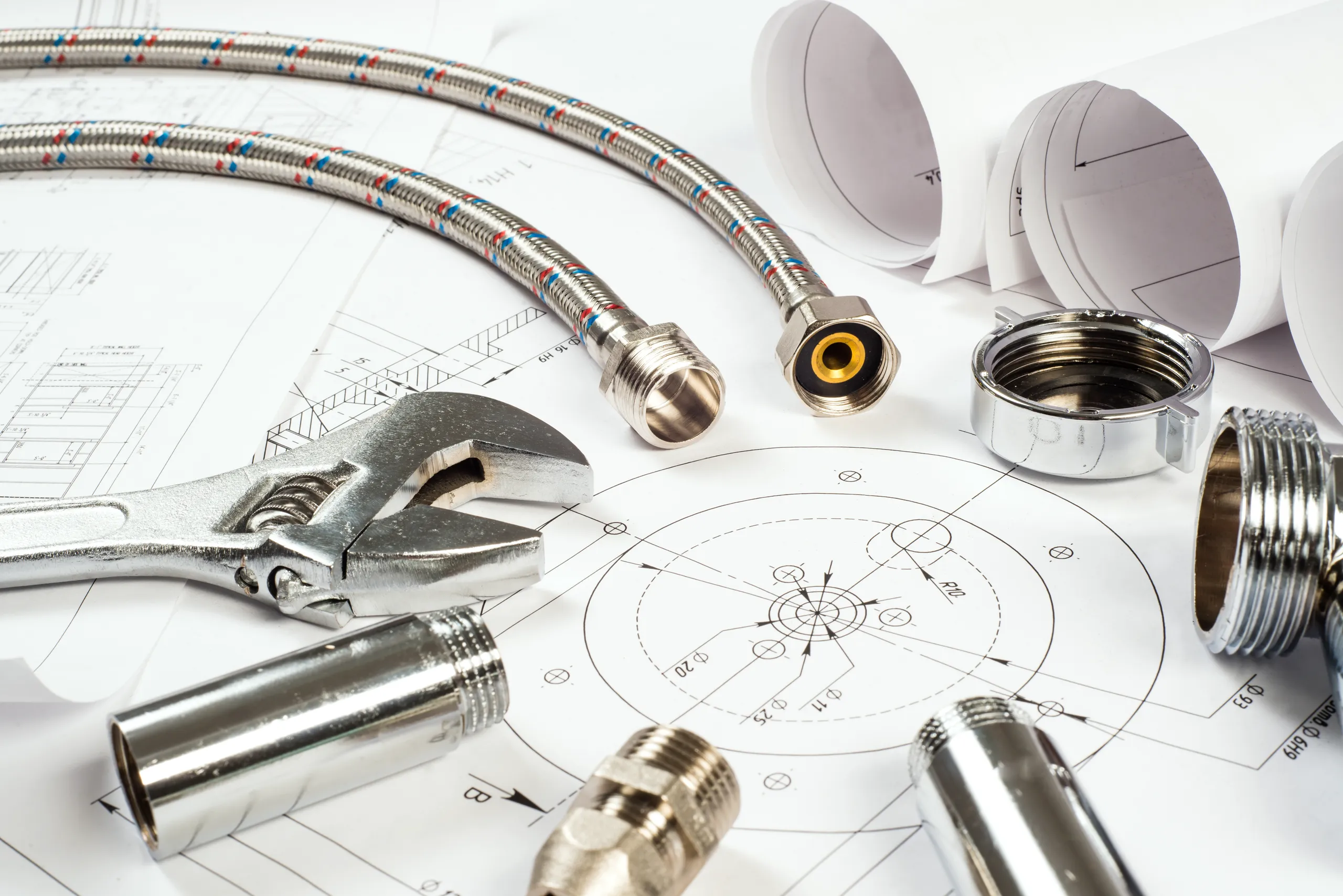 Close-up of plumbing tools and fittings on technical drawings for plumbing installation