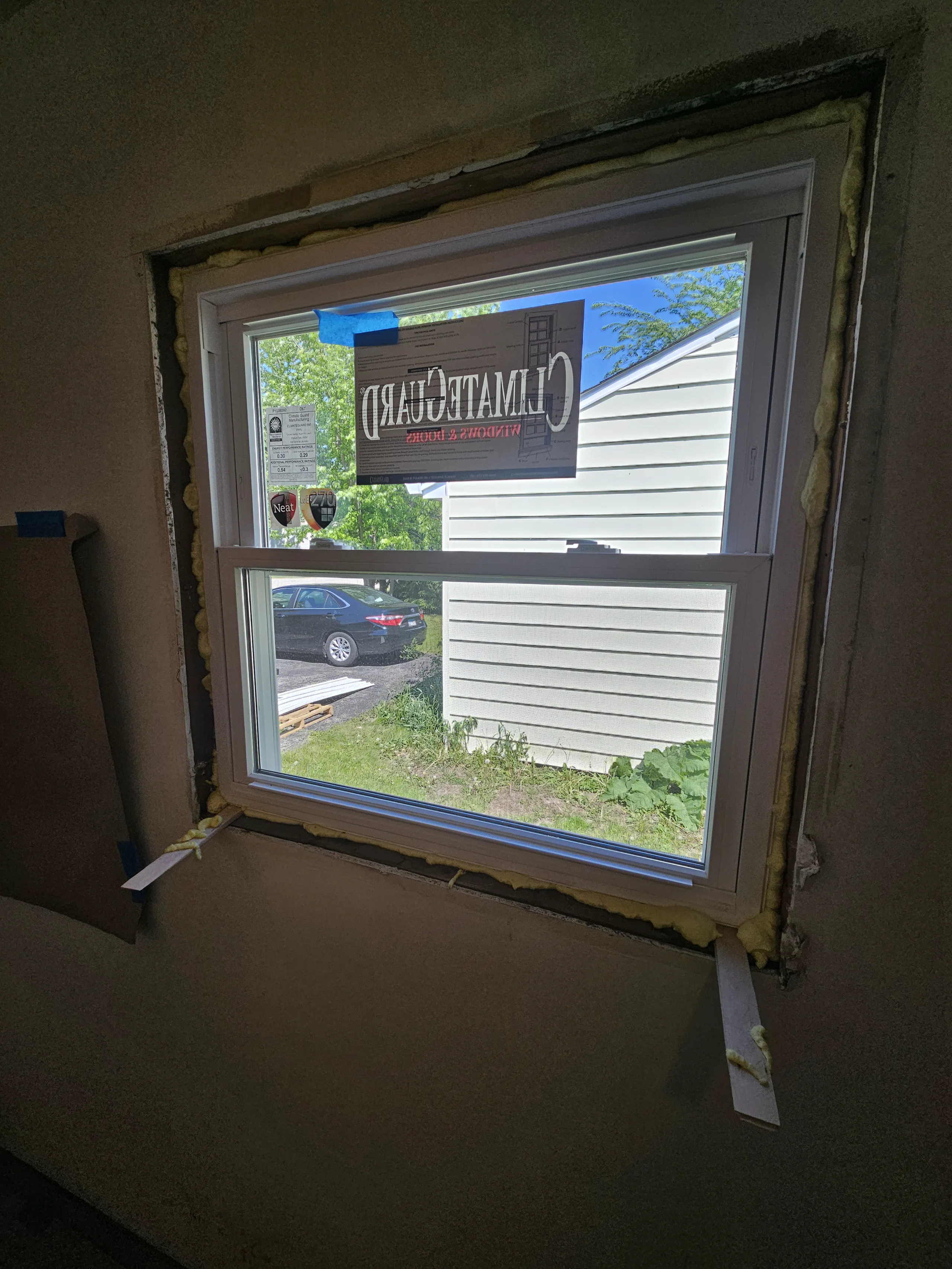 Window installation in progress, featuring a newly framed window with insulation
